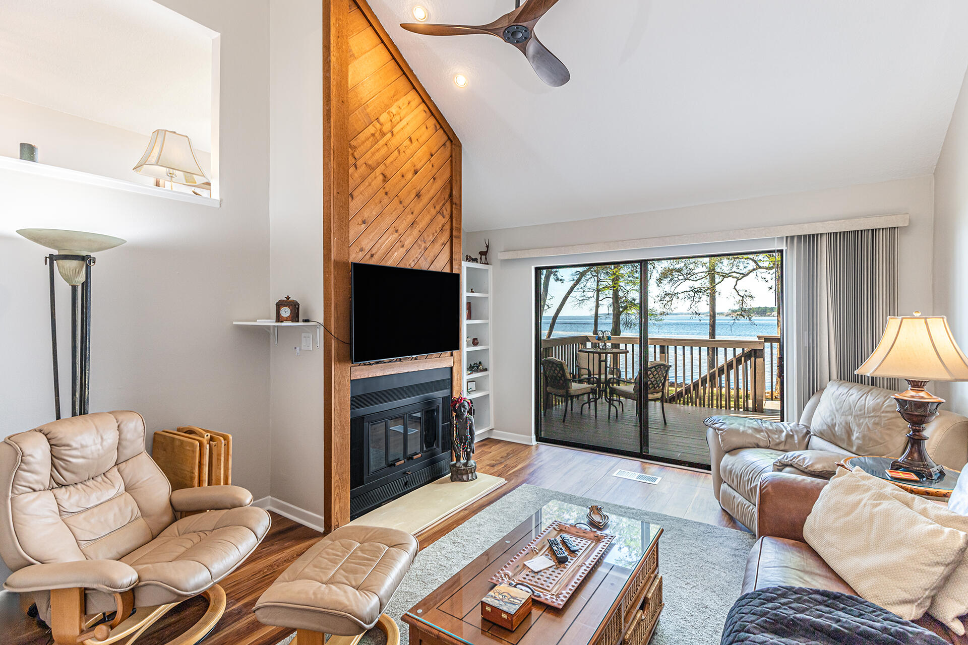 a living room with furniture a flat screen tv and a floor to ceiling window