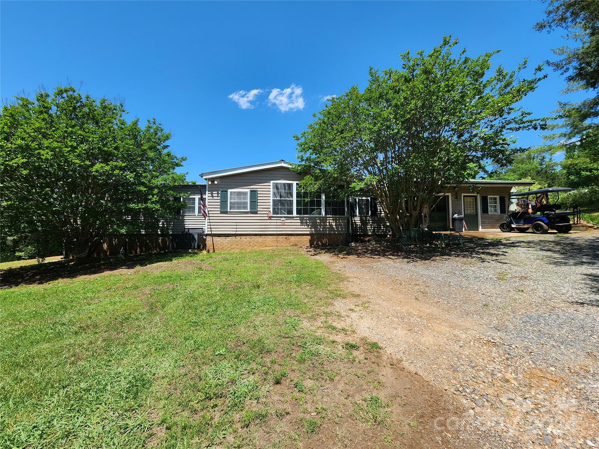 a front view of a house with a yard and trees