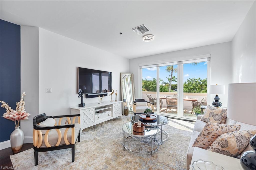 a living room with furniture a flat screen tv and a large window