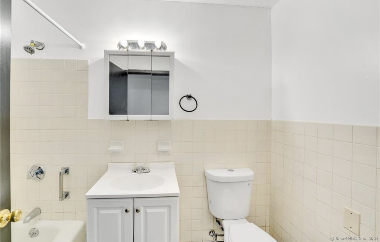 a bathroom with a sink a toilet and mirror