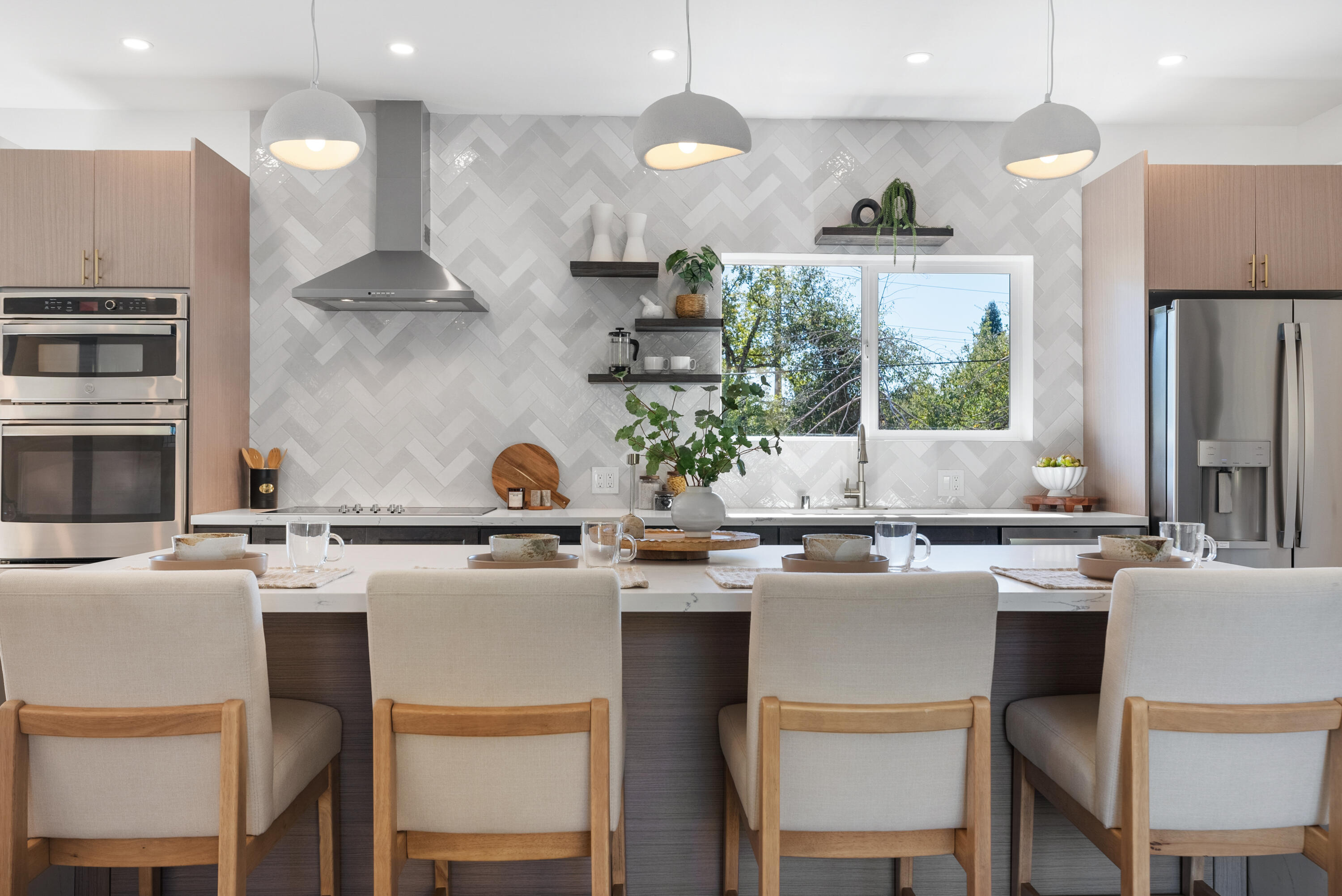 a kitchen with a stove a sink a refrigerator and chairs