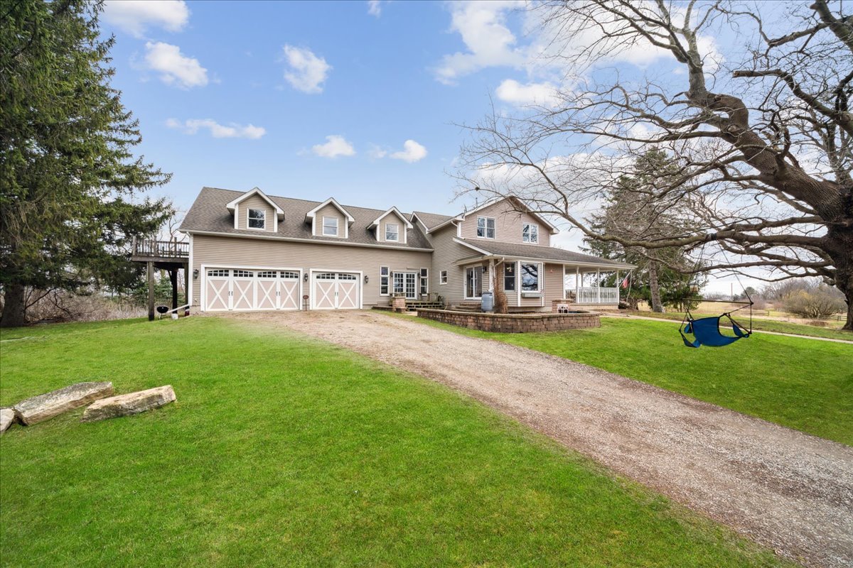 a view of a house with a big yard plants and large trees