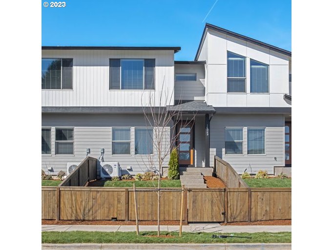 a view of a house with a yard and wooden fence