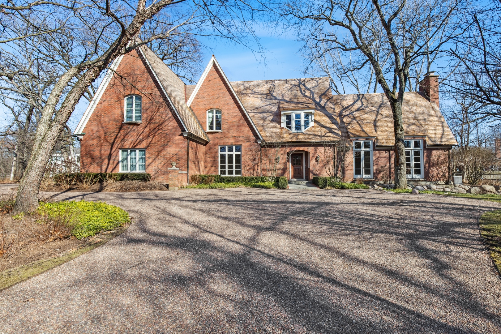 a front view of house with a yard and trees around