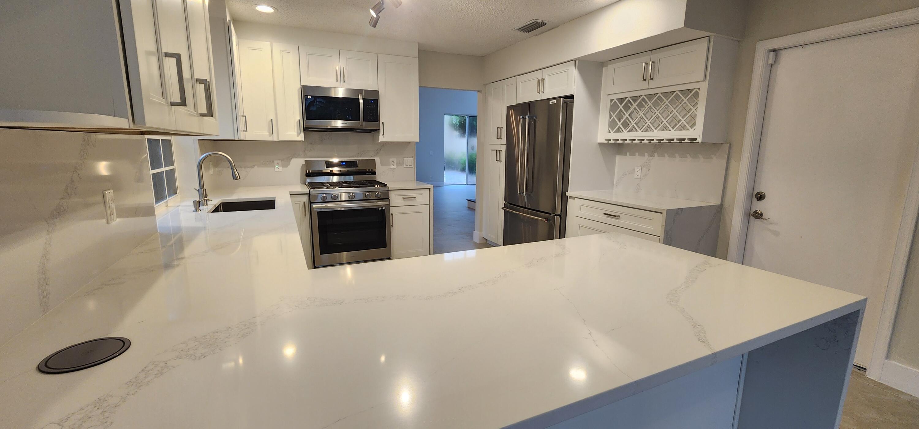 a kitchen with stainless steel appliances a refrigerator sink and stove top oven