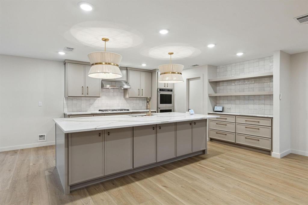 a large kitchen with kitchen island a sink stainless steel appliances and cabinets