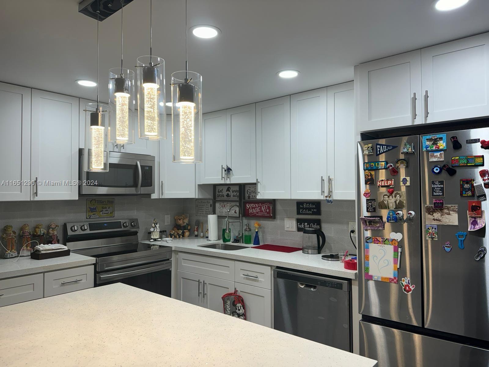 a kitchen with stainless steel appliances granite countertop a refrigerator and sink