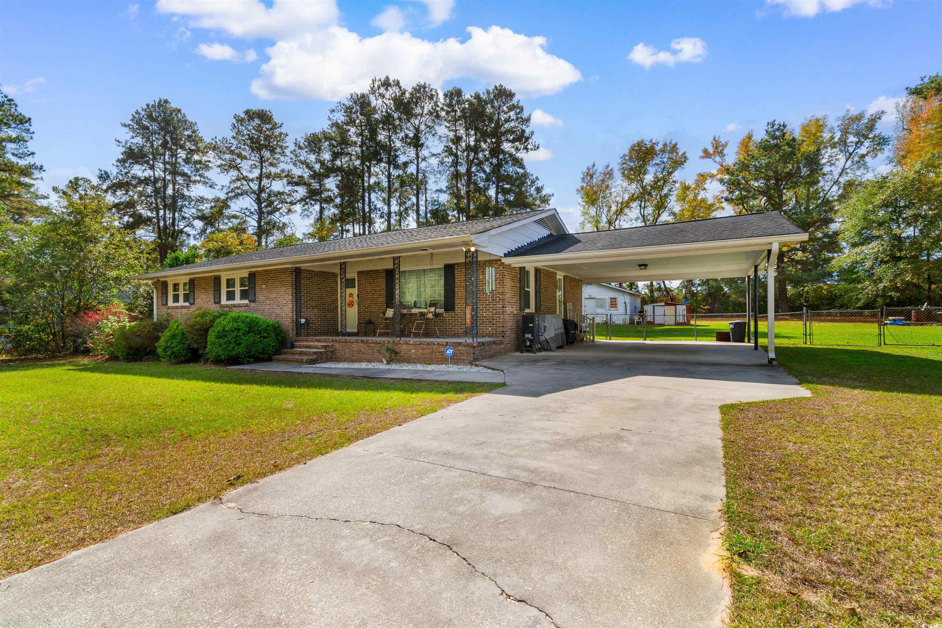 Single story home with covered porch, a front lawn