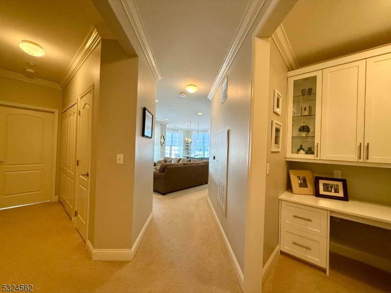 a view of a hallway with a dining table and chairs