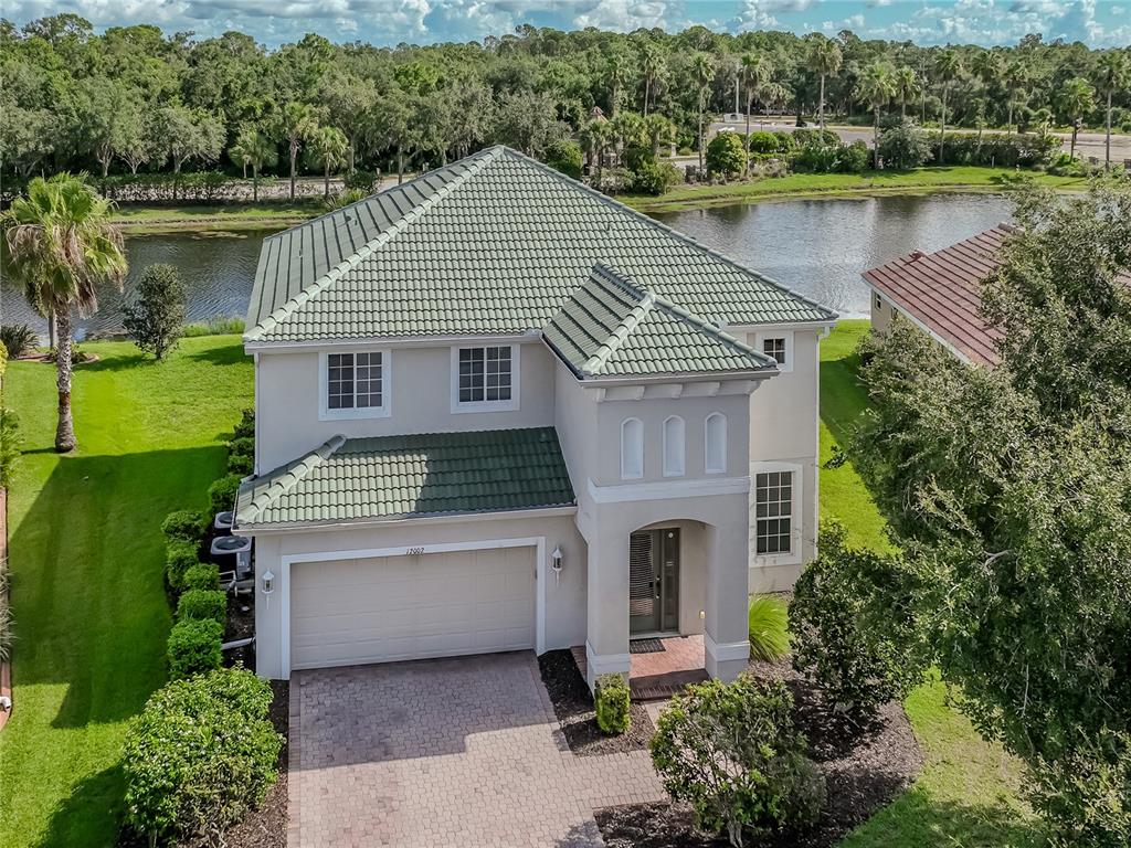 a front view of a house with a garden and lake view