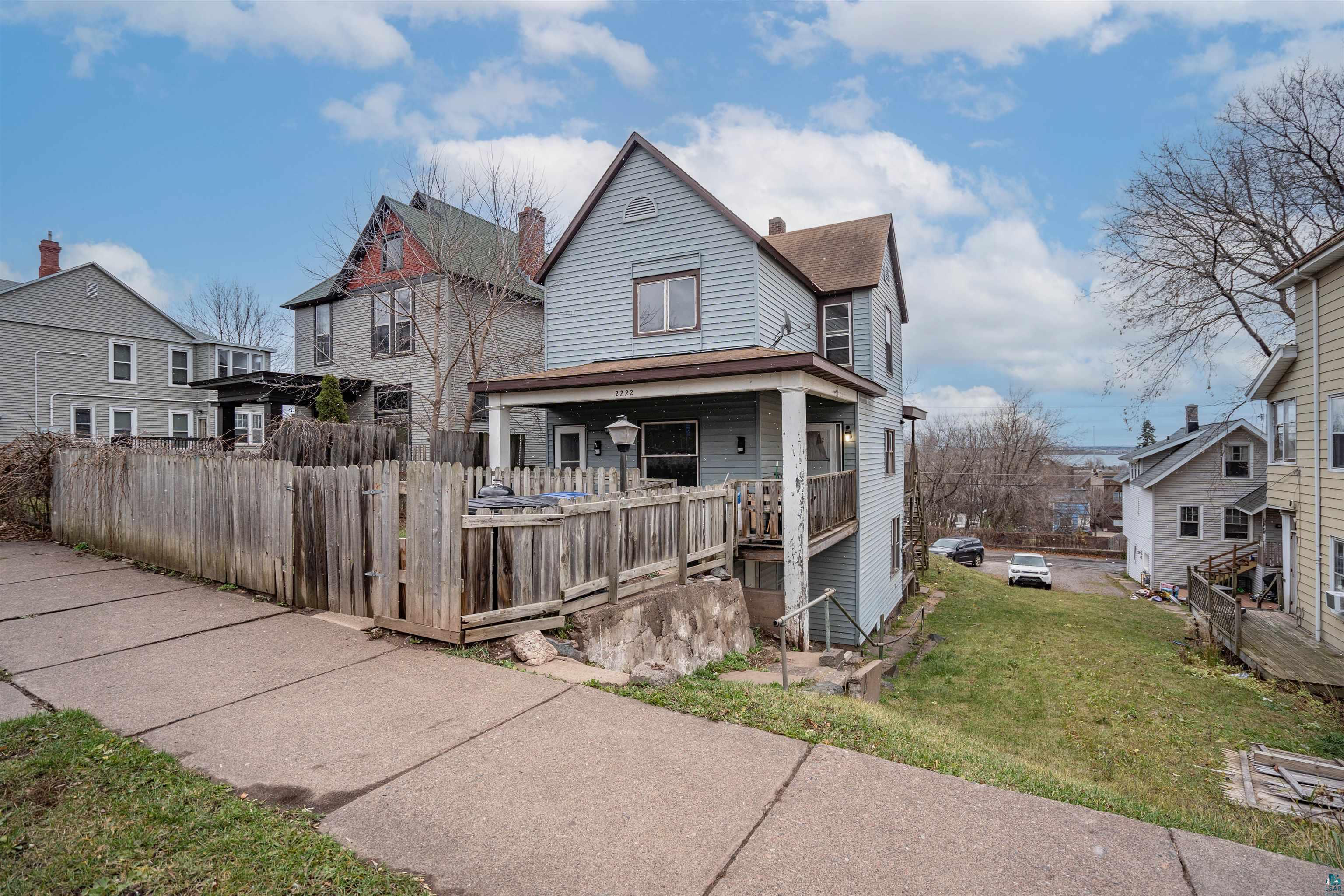 View of front of home with covered porch and a front yard