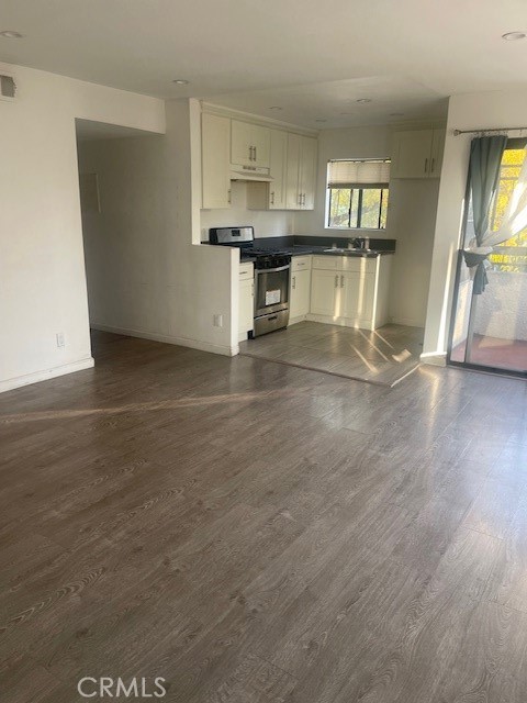 a view of a kitchen with wooden floor and electronic appliances