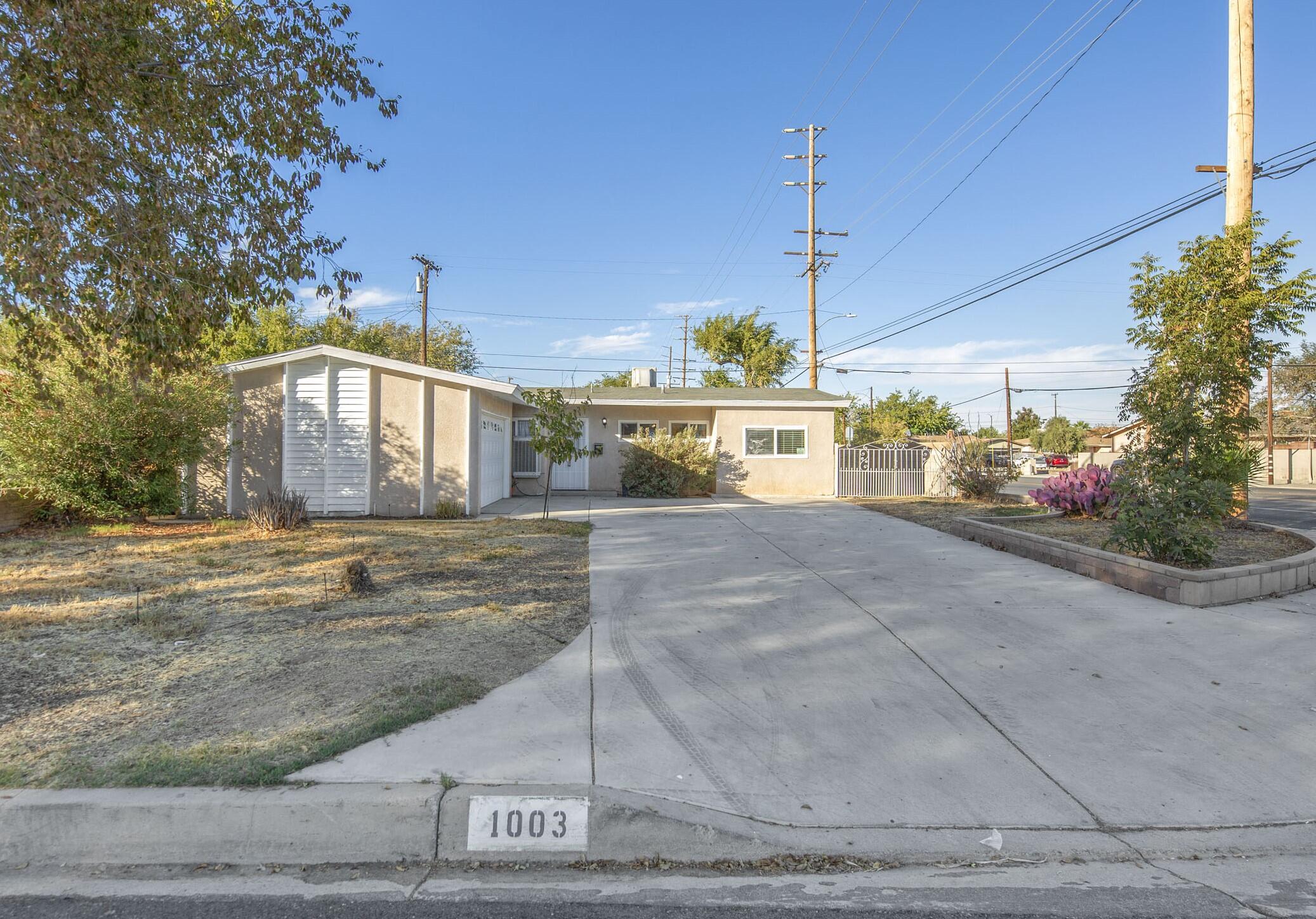 a front view of a house with a yard and potted plants