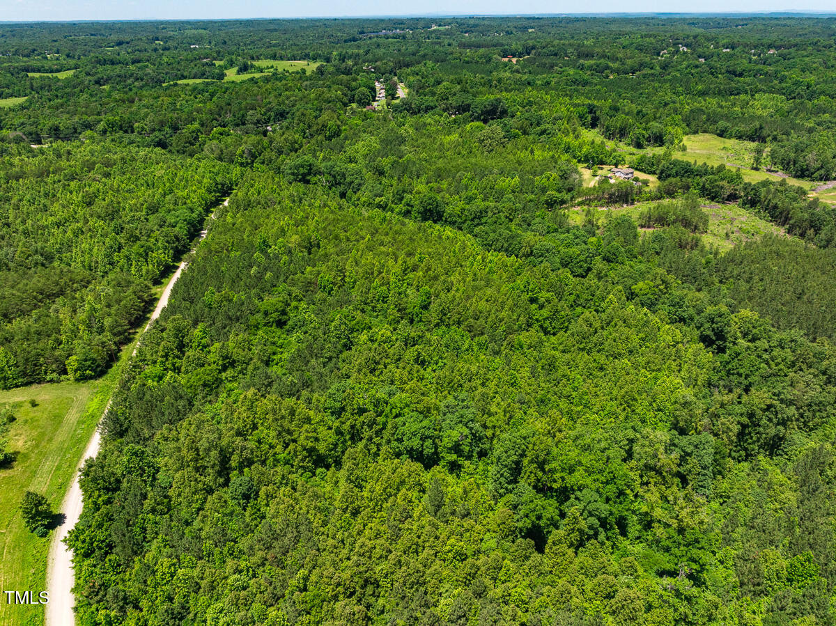 an aerial view of residential houses with outdoor space and trees