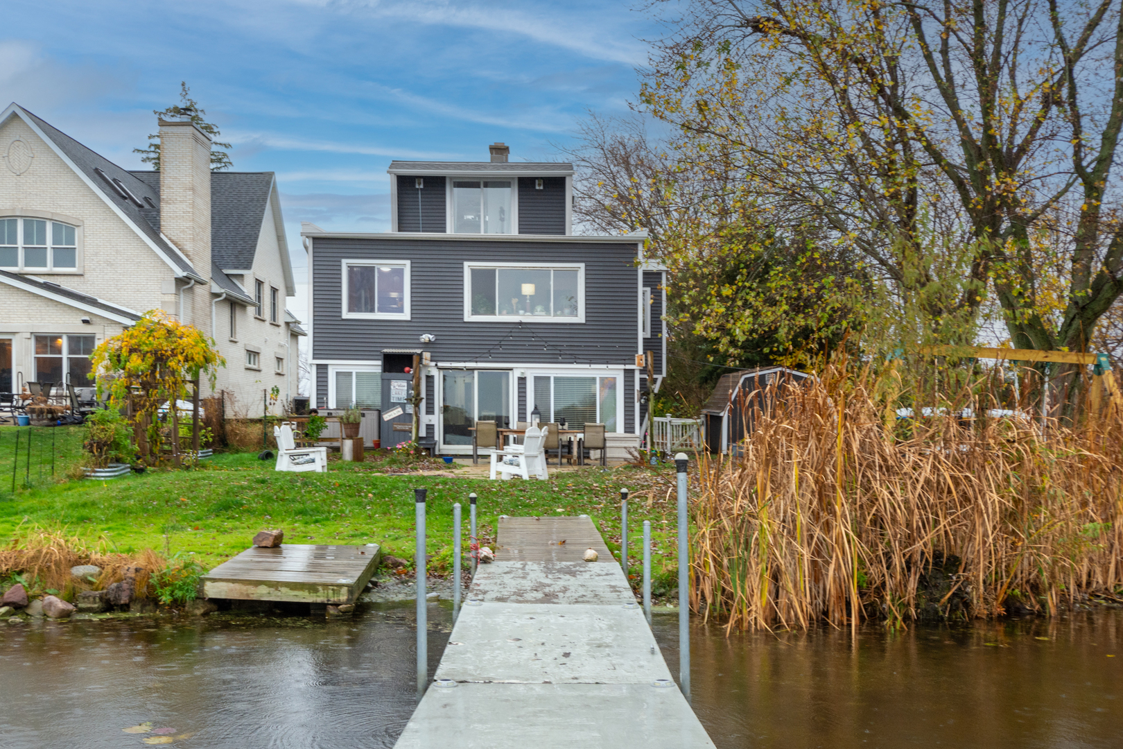 a front view of a house with a garden and lake view