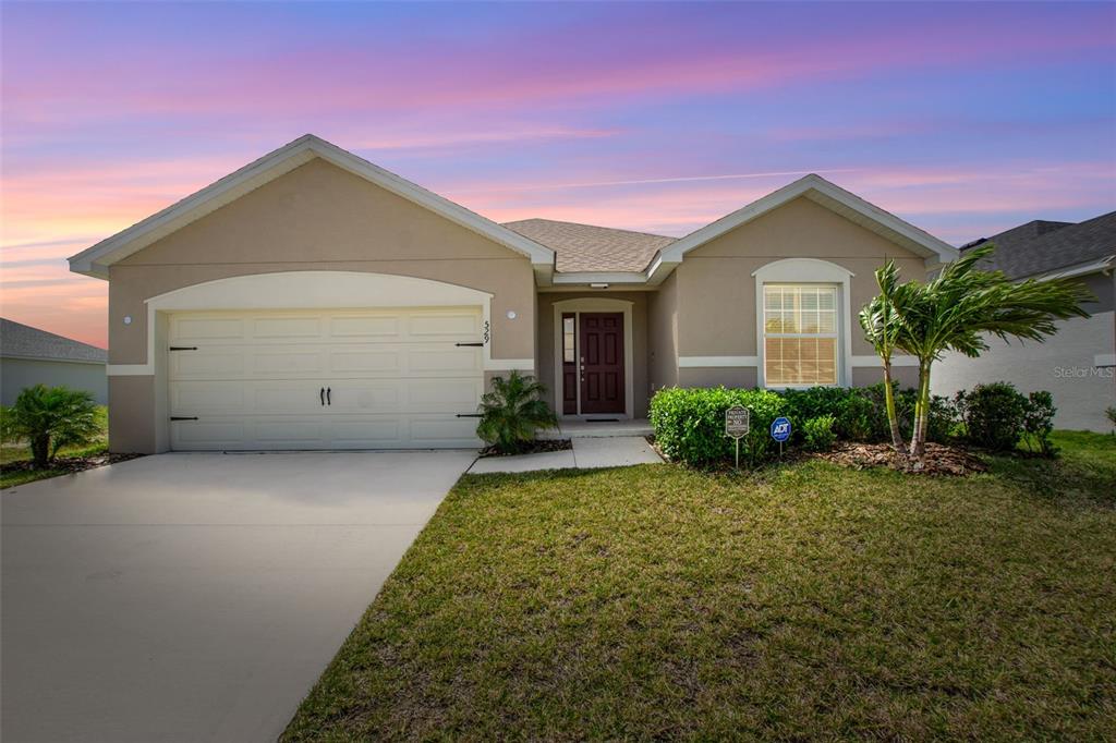 a front view of a house with a yard and garage