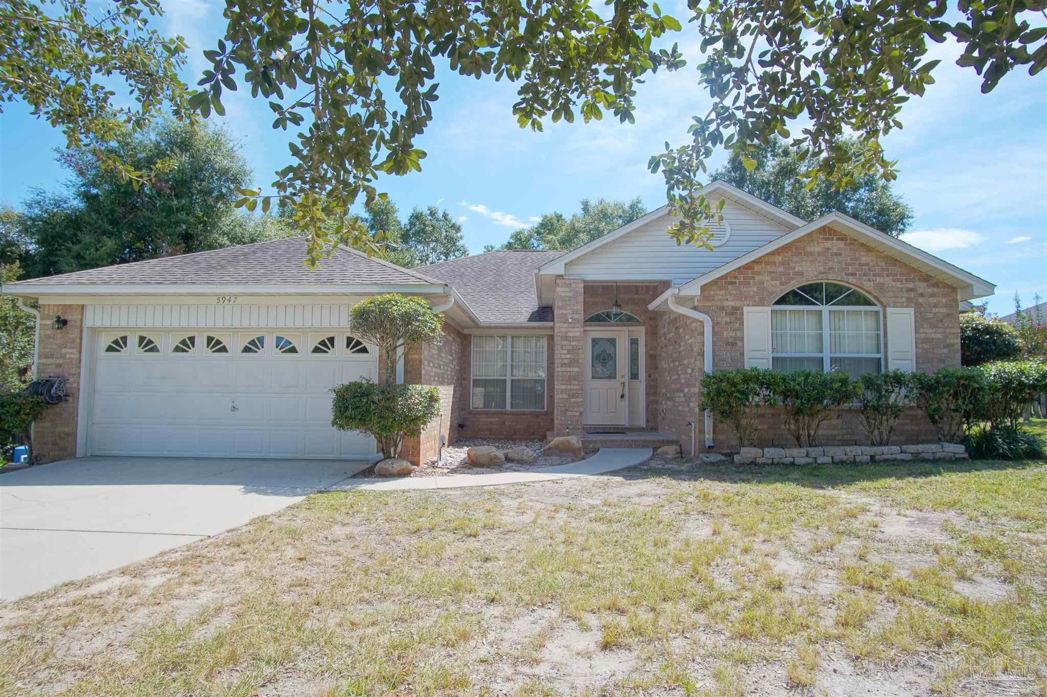 a view of a house with a yard and tree s