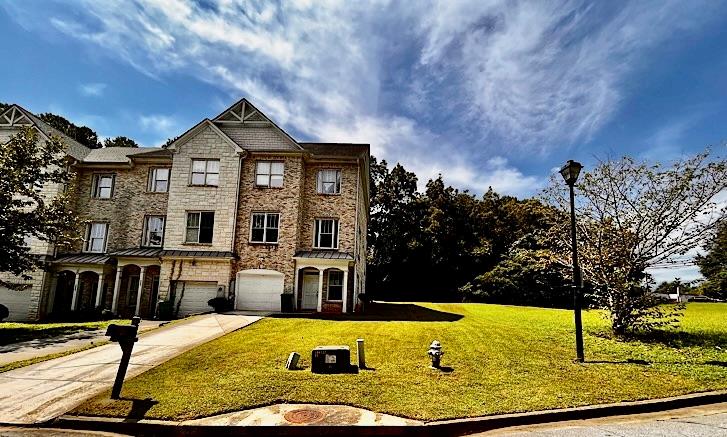 a view of a house with yard and sitting area