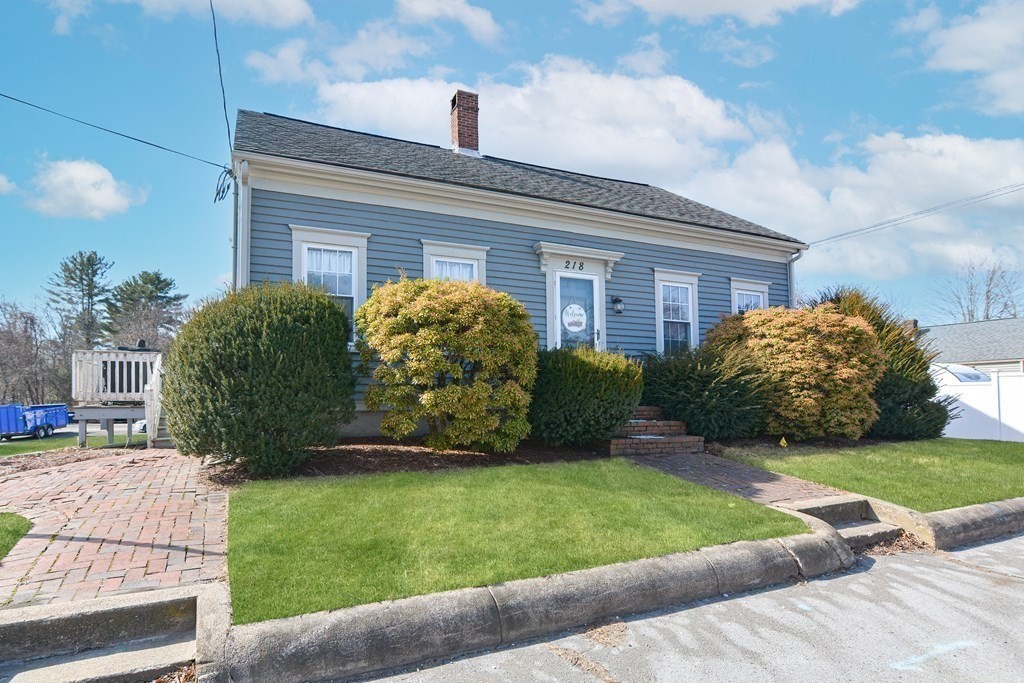 a view of a house with a yard and pathway