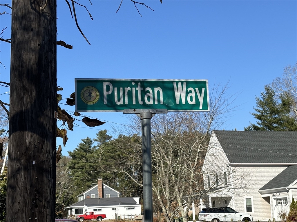 a street sign on a wall next to a road