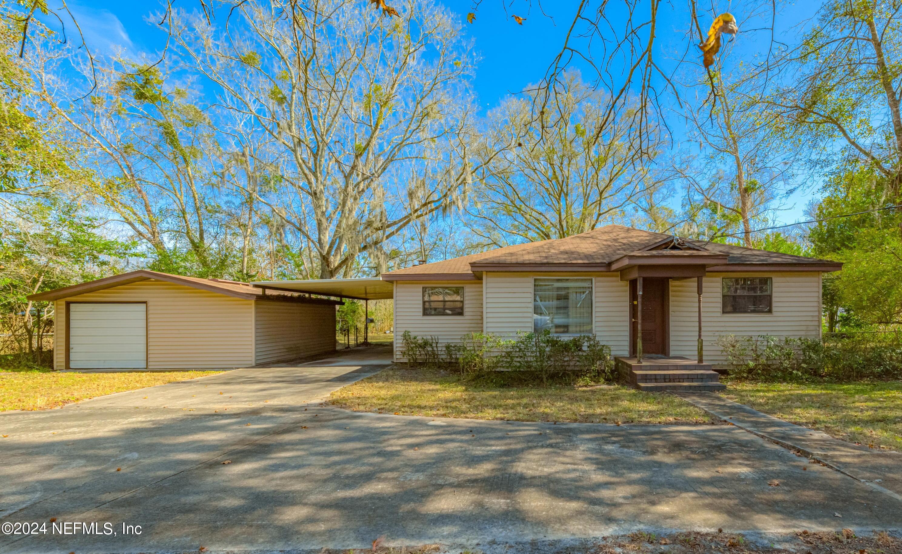 a front view of house with yard and trees around