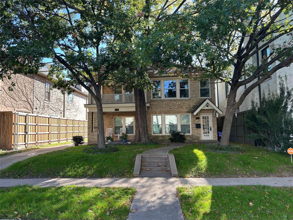 a front view of a house with a yard and shrubs