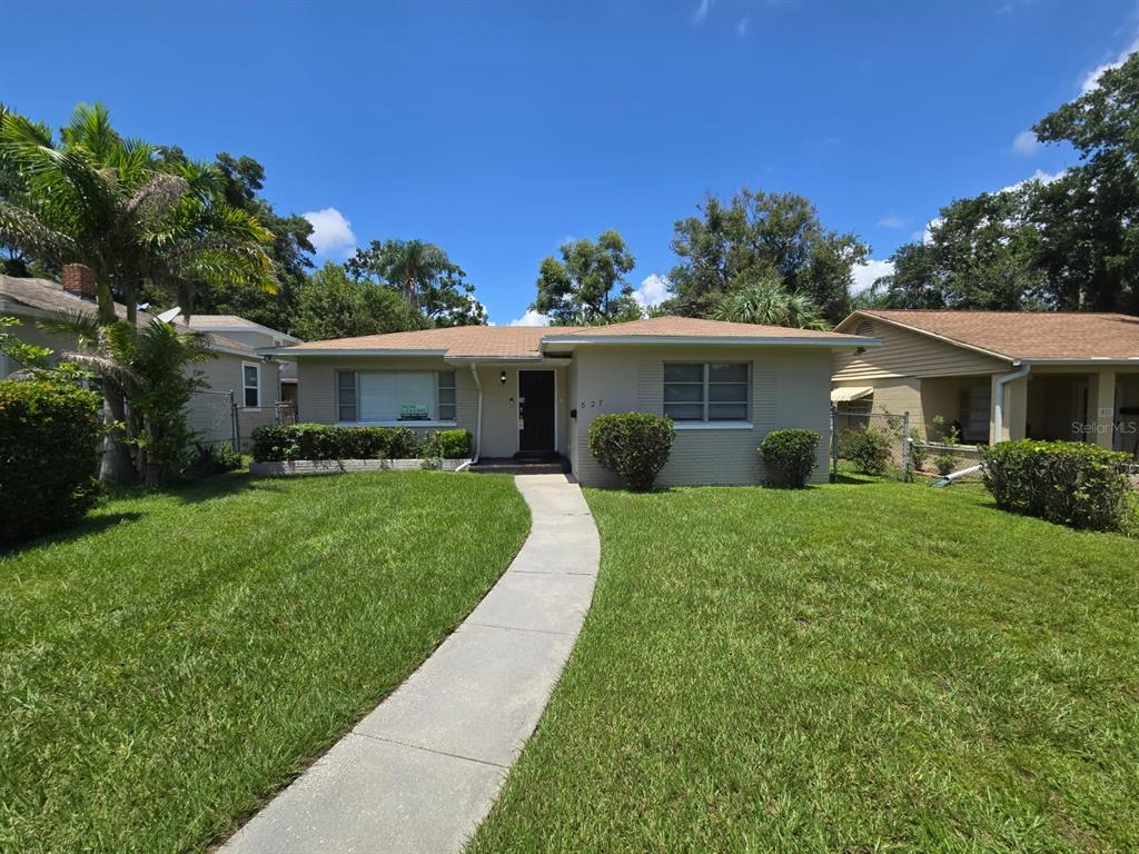 a front view of house with a yard and green space