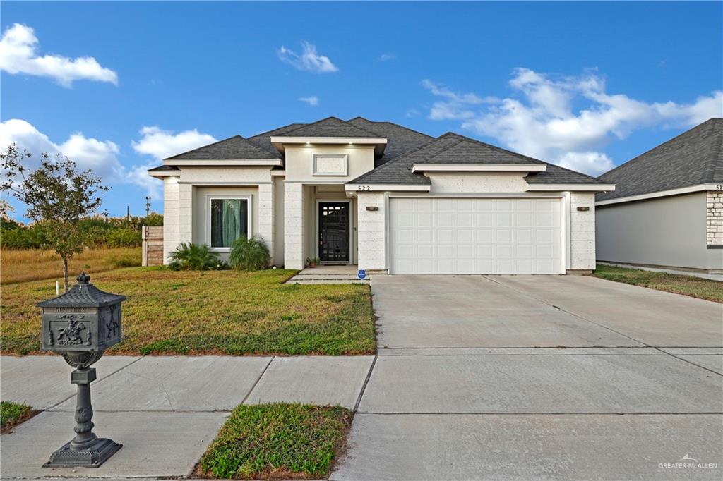 View of front of property with a garage and a front yard