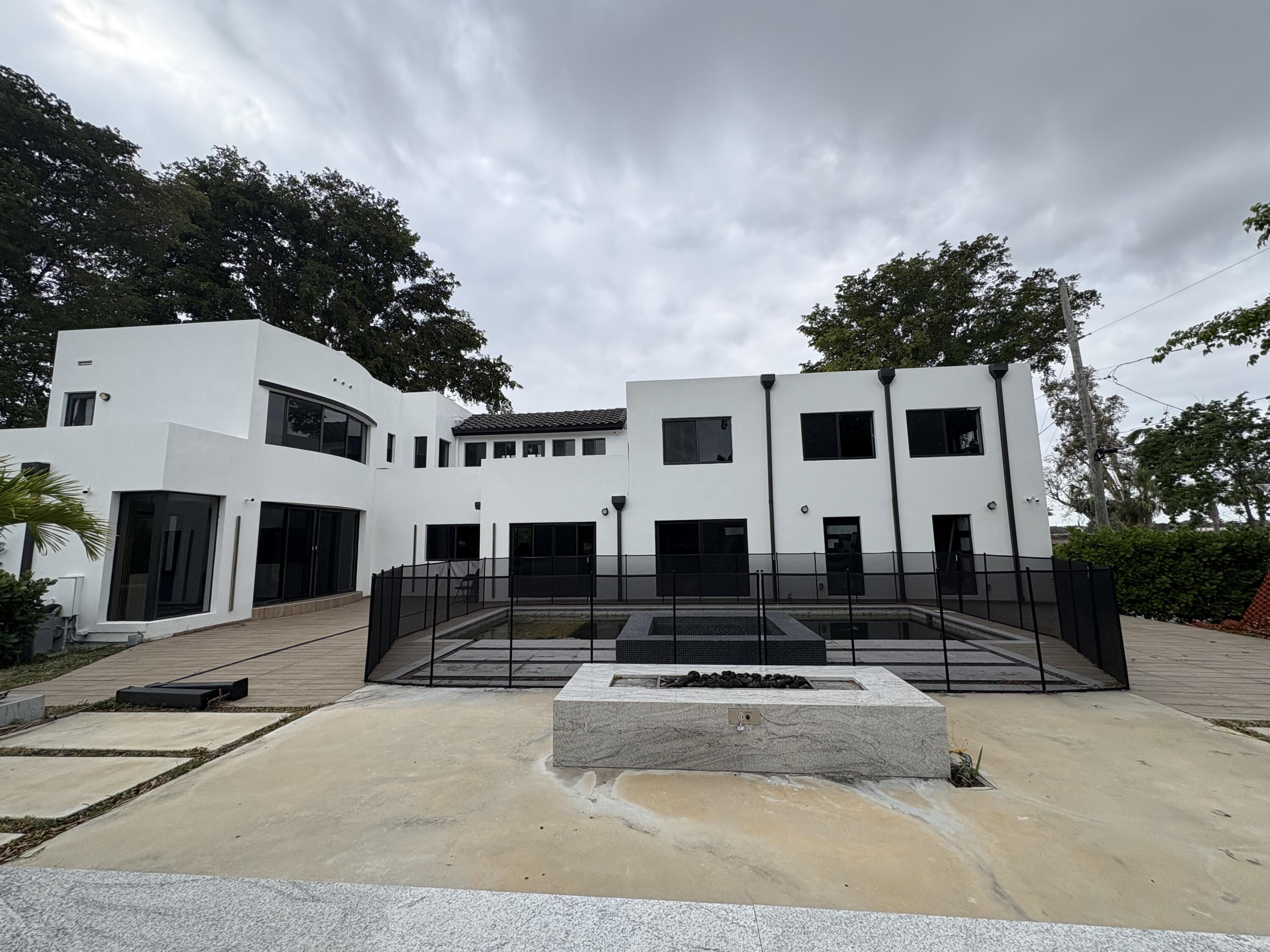 a front view of a house with lots of windows and plants