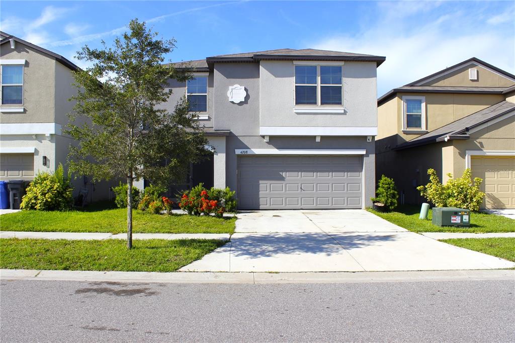 a front view of a house with a yard and garage