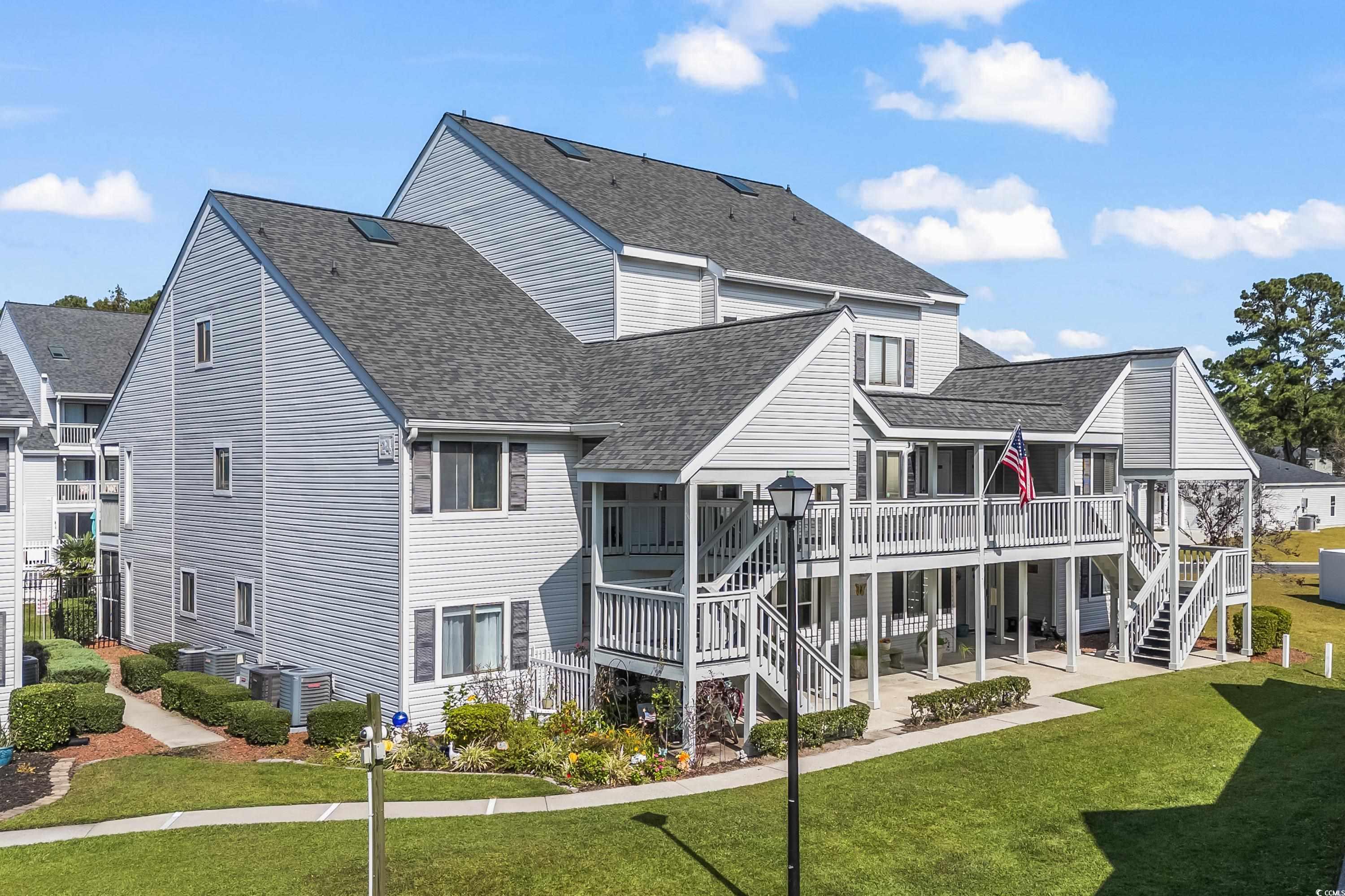 Back of house with a yard, a patio, and a wooden d