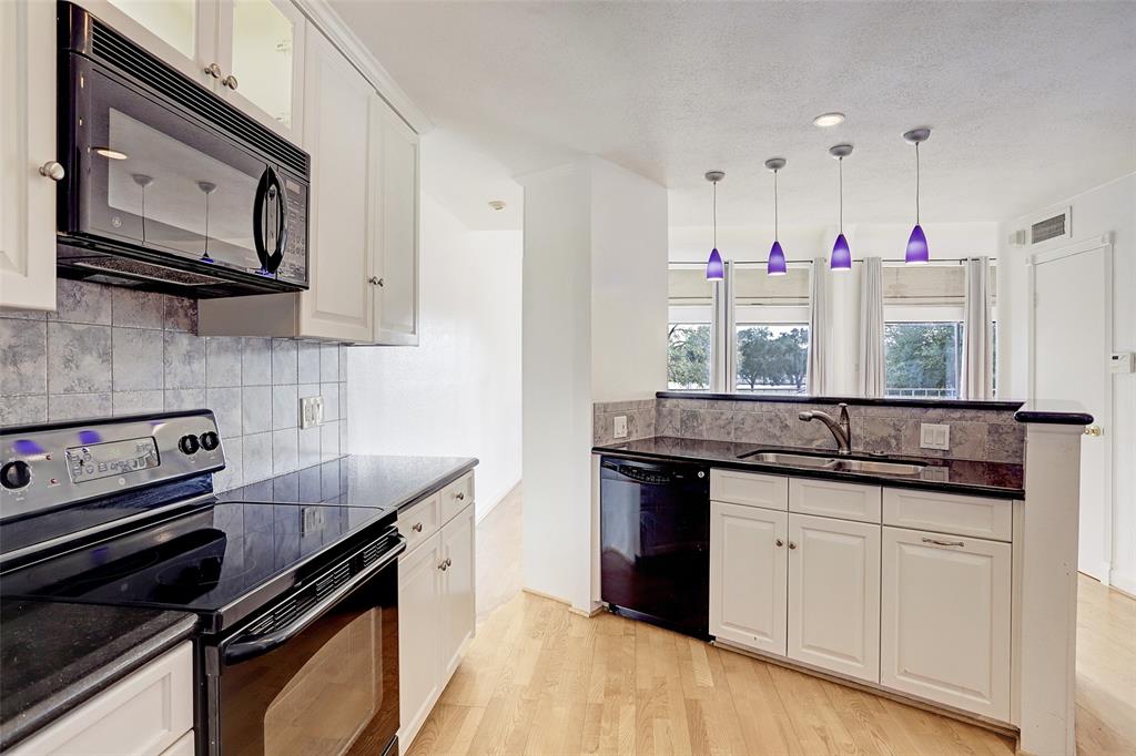 a kitchen with granite countertop a stove sink and cabinets