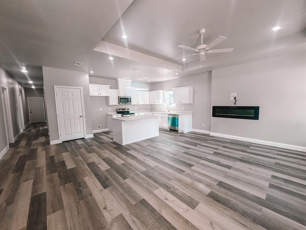 a view of kitchen with refrigerator microwave and cabinets