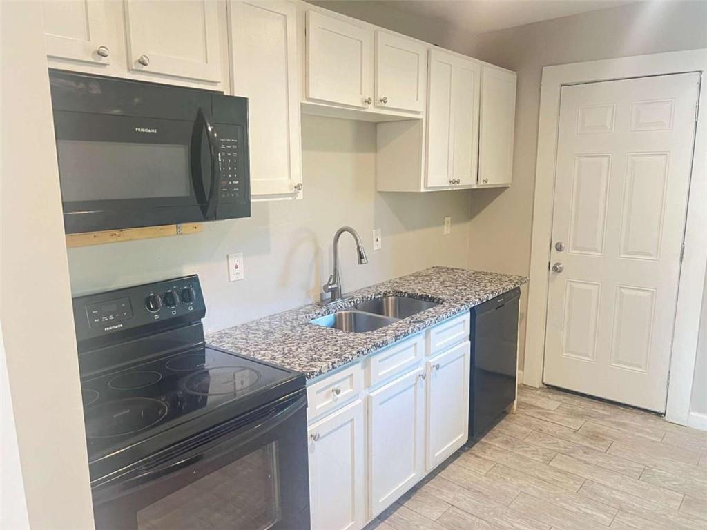 a kitchen with granite countertop a sink and cabinets