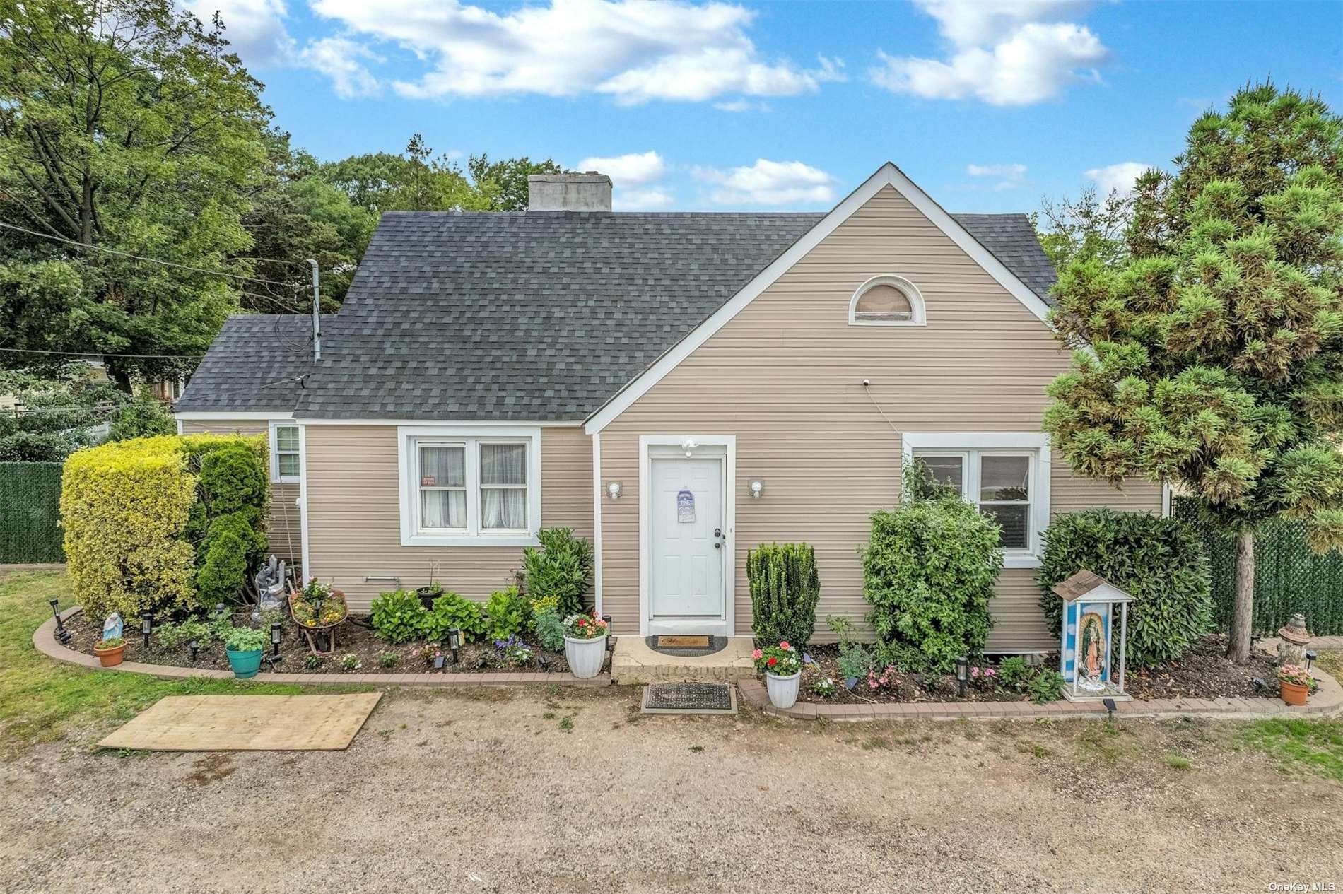 a view of a house with a yard and potted plants