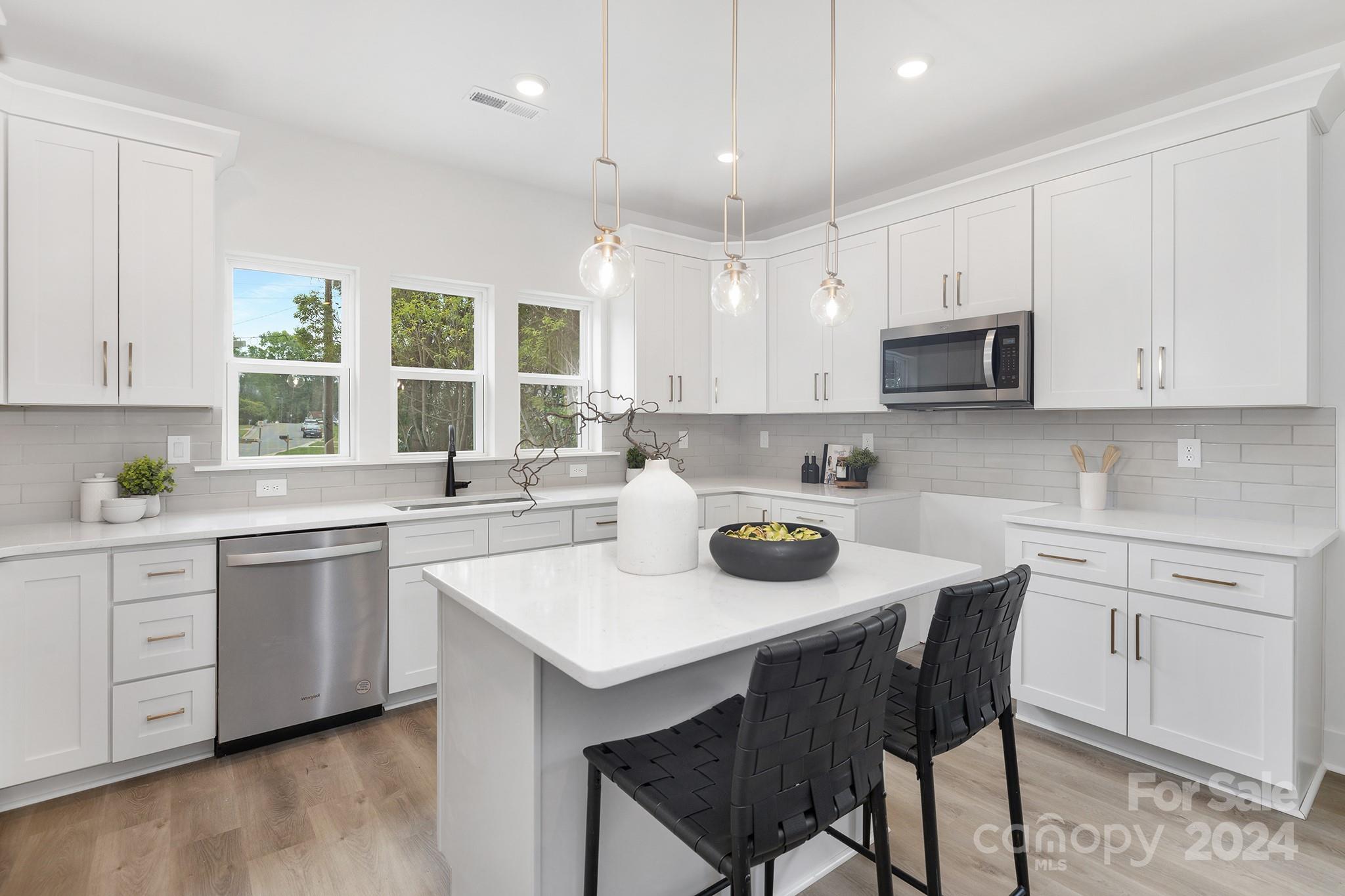 a kitchen with a sink stove a microwave and cabinets