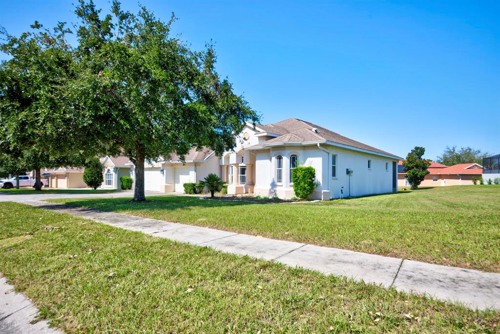 a front view of a house with a yard and trees