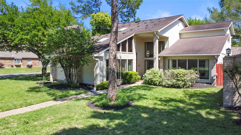 Welcome to this two-story home with a brick facade, large windows, surrounded by well-maintained, mature landscaping.