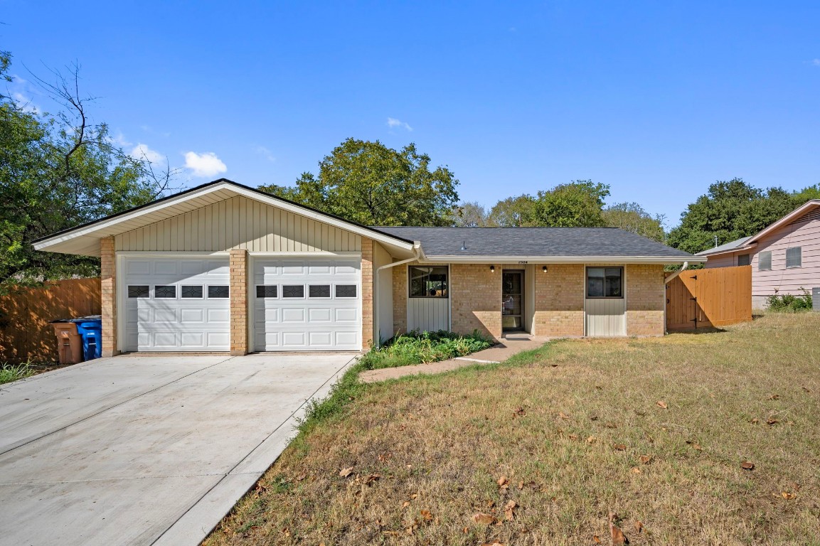 a front view of house with yard and trees in the background