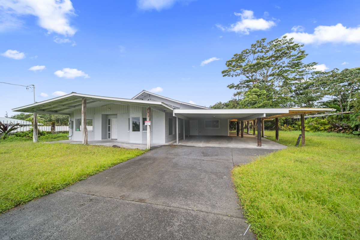 a view of a house with a yard and sitting area