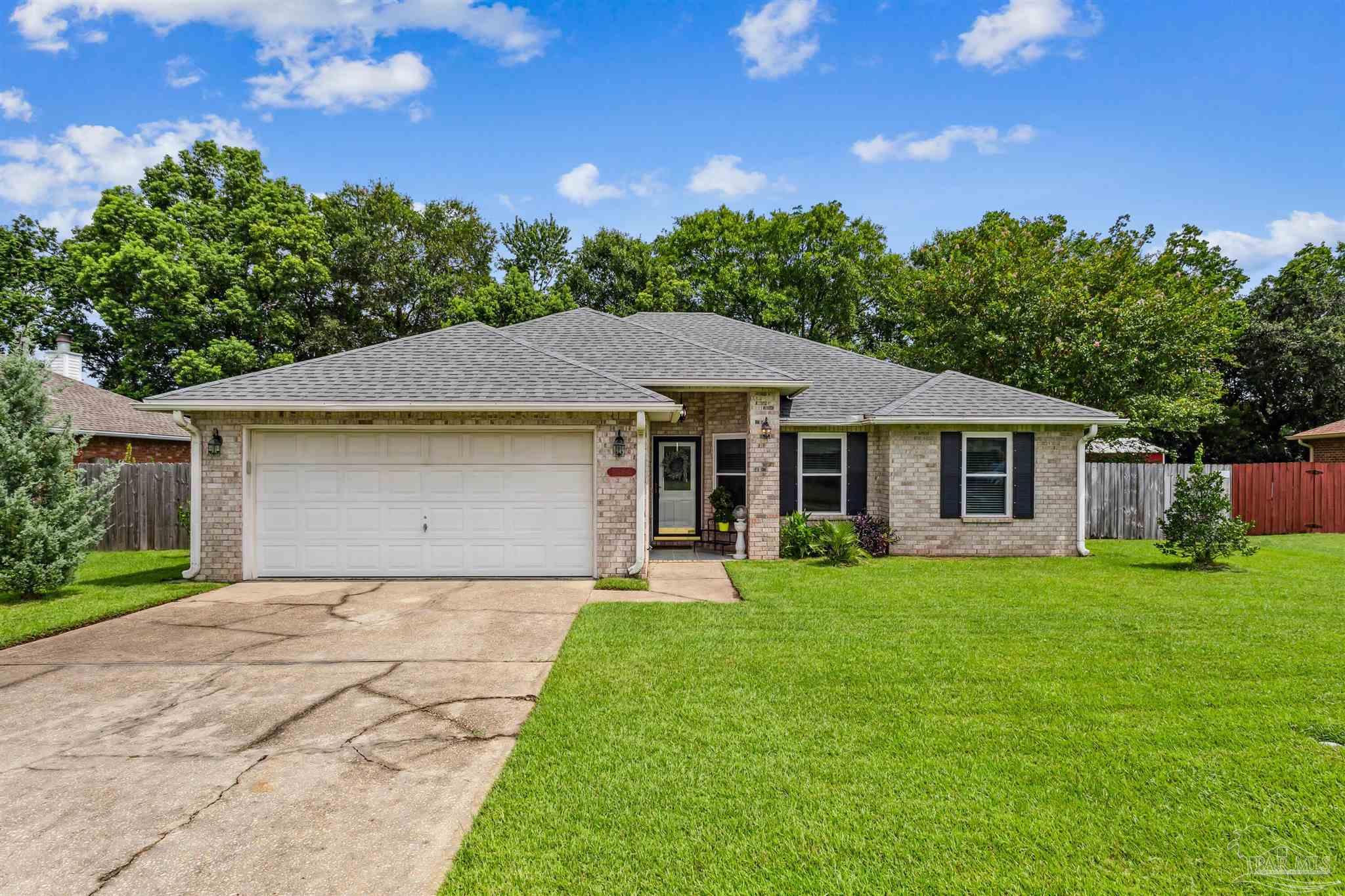 a front view of a house with a yard and trees