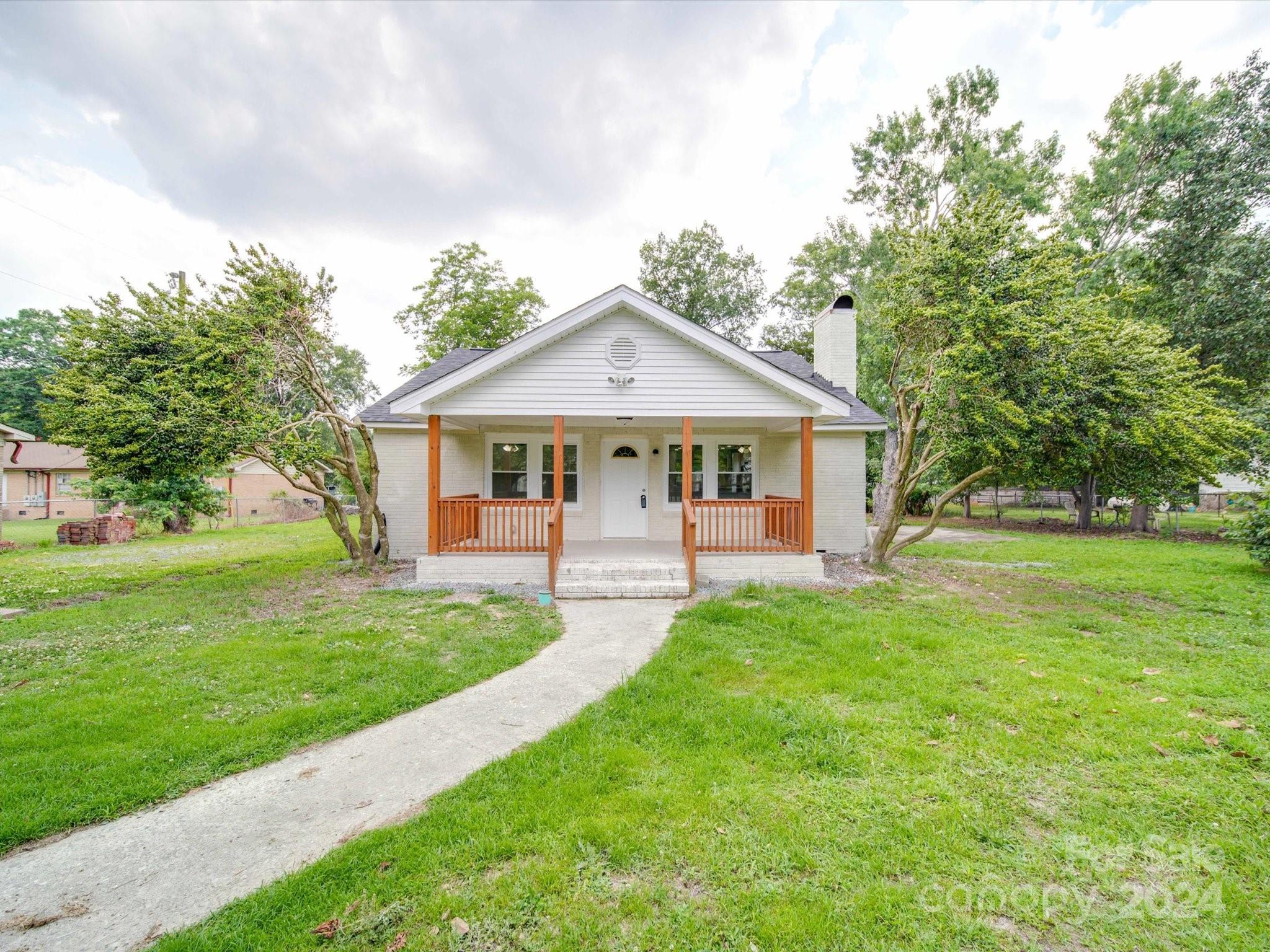 a front view of a house with a yard and trees