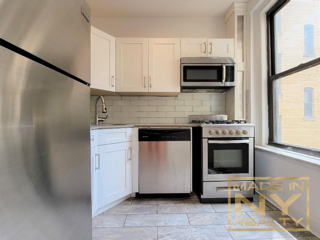 a kitchen with stainless steel appliances a stove microwave and sink