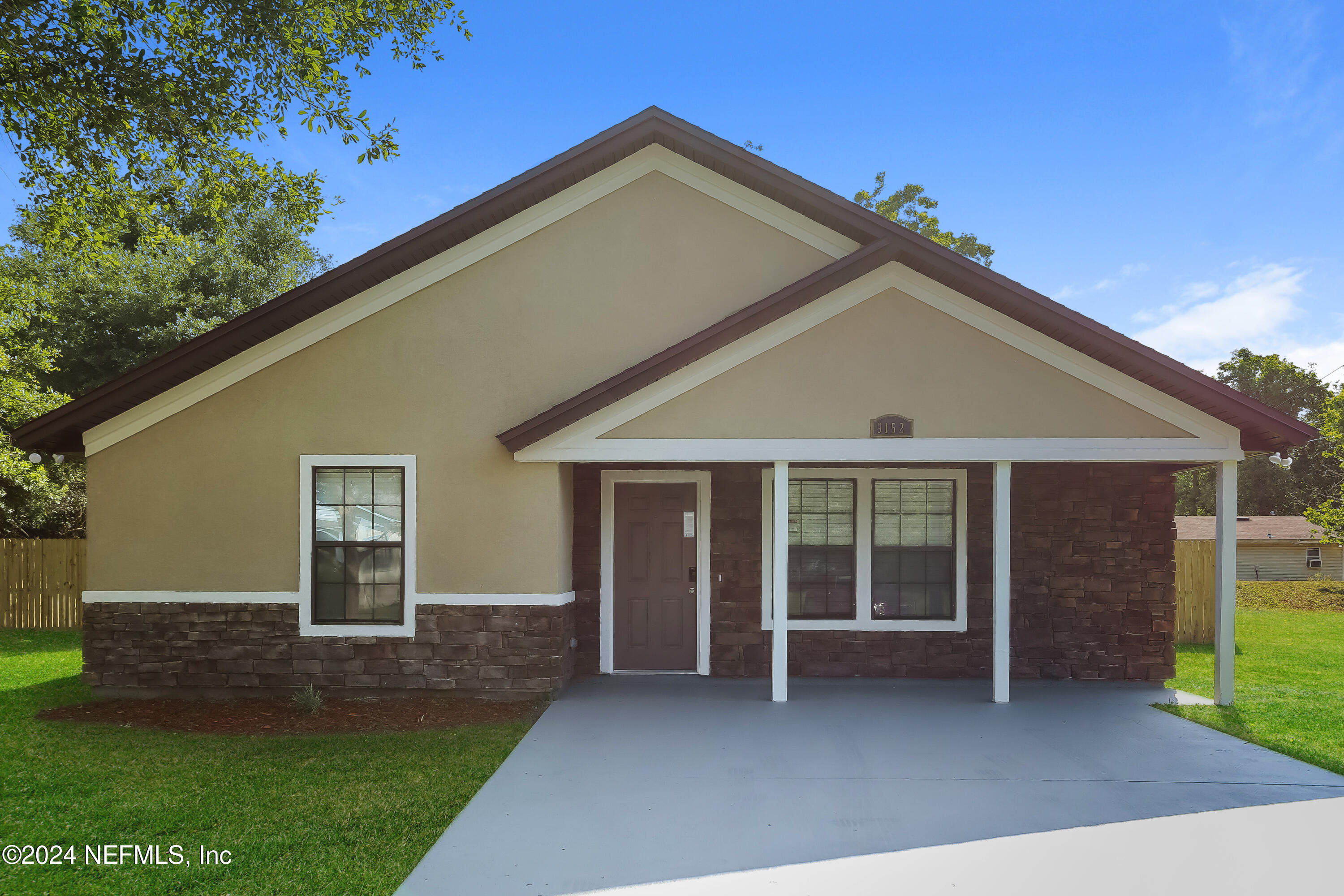 a front view of a house with a garden and yard