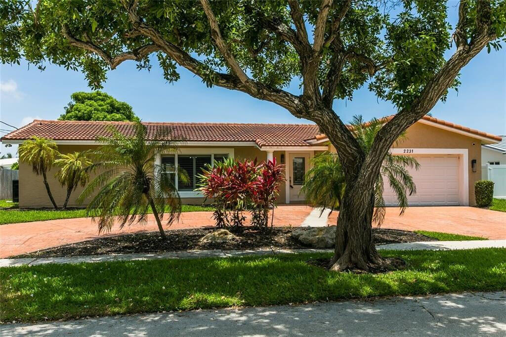 a view of a house with backyard and a tree