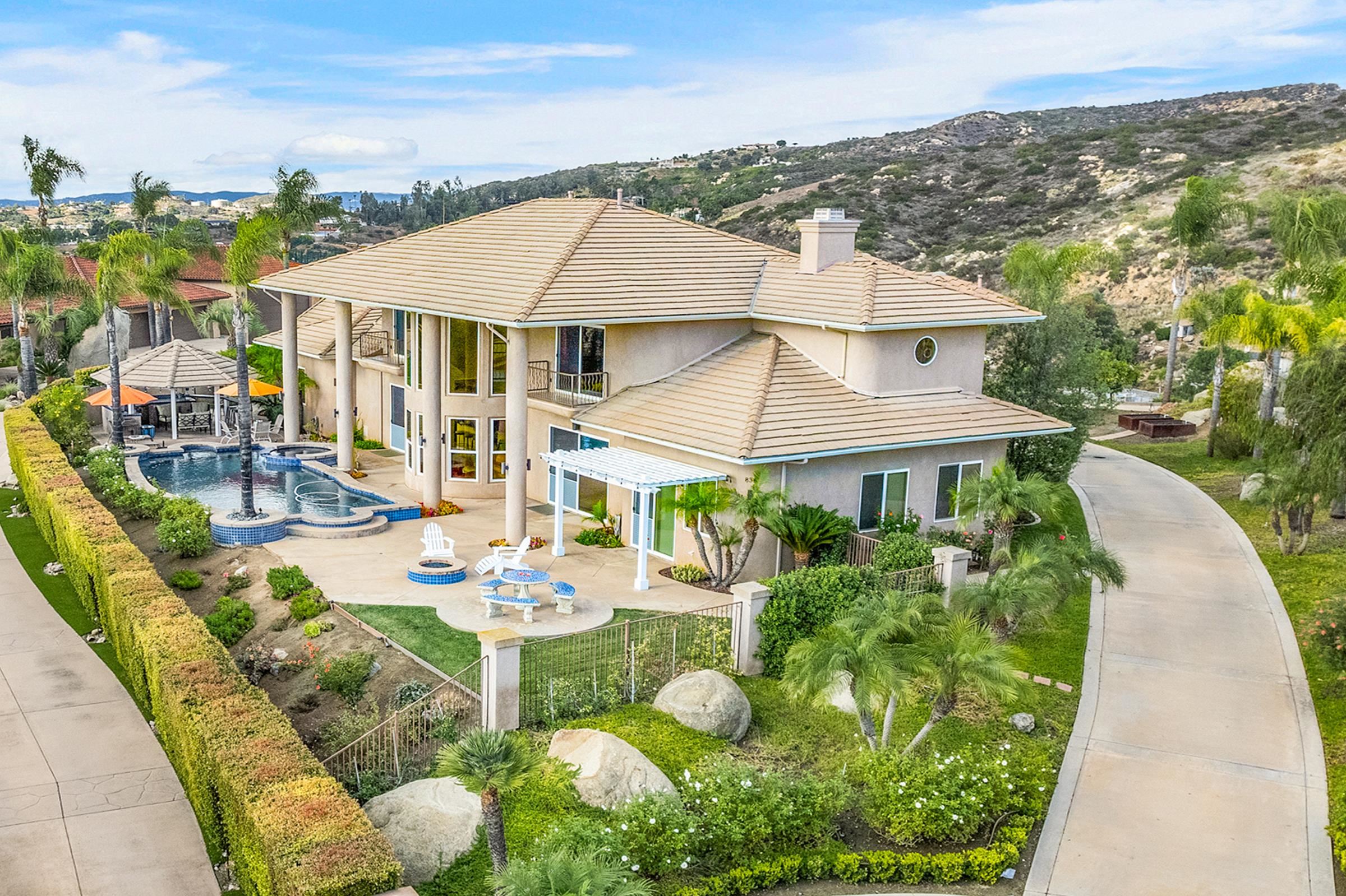 an aerial view of a house with swimming pool garden and mountain view