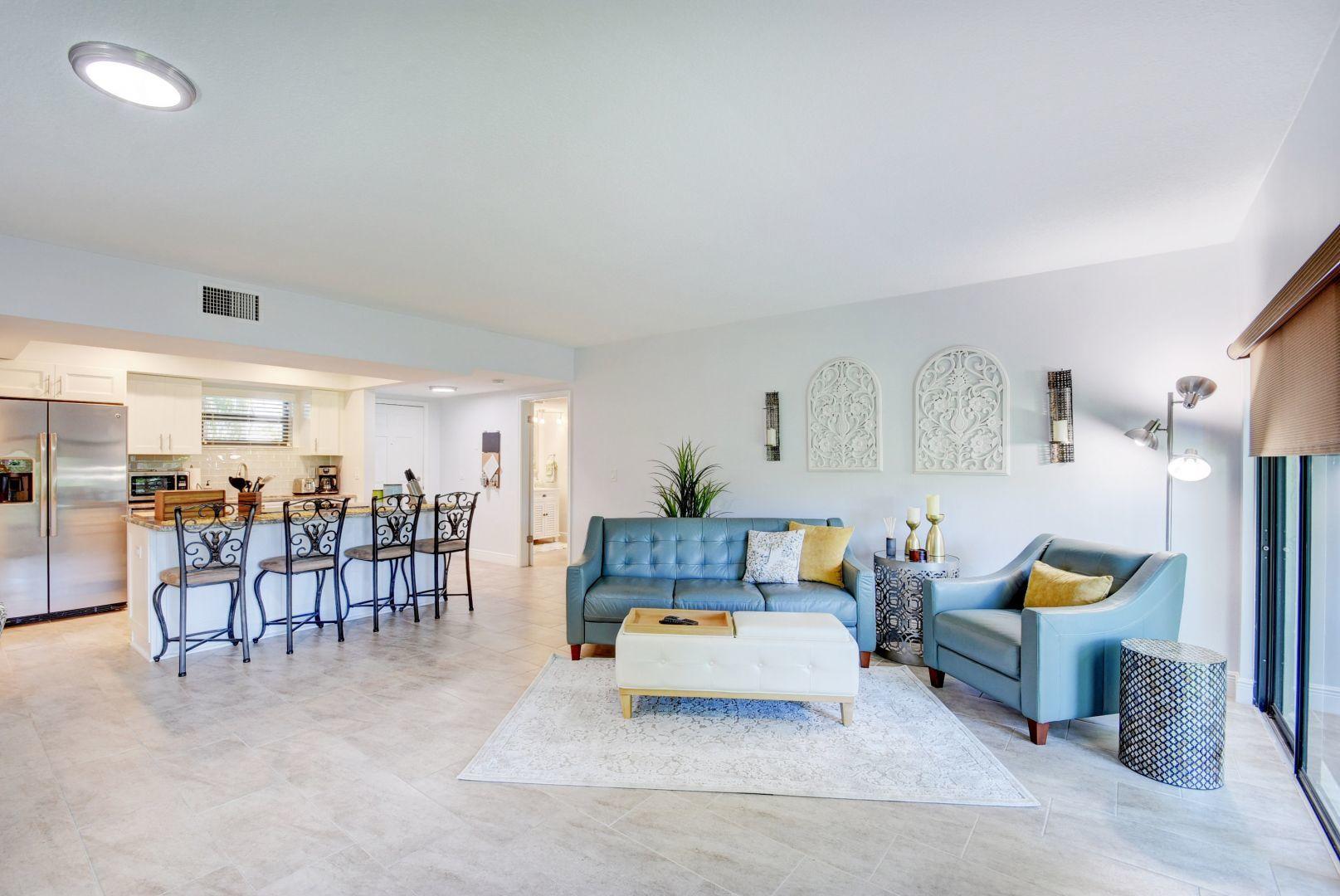 a living room with furniture and a dining table with chairs