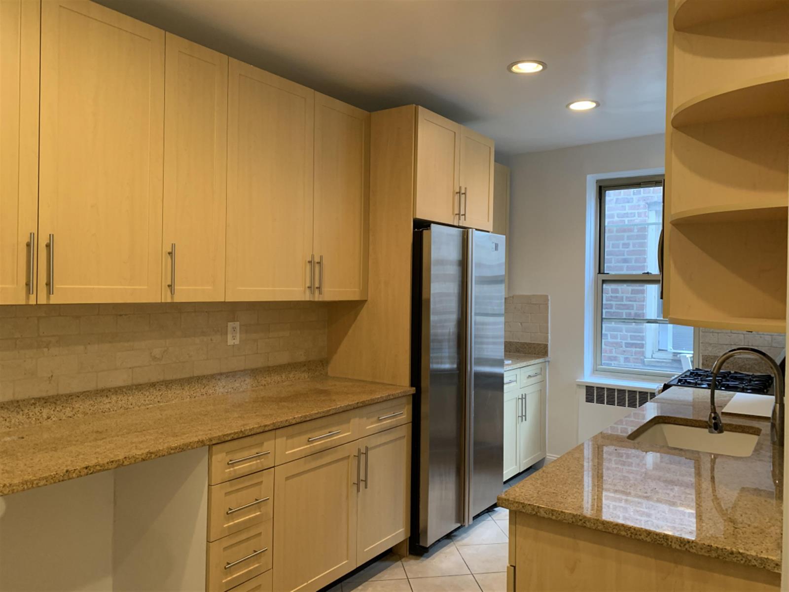 a kitchen with stainless steel appliances granite countertop a sink a stove and a refrigerator