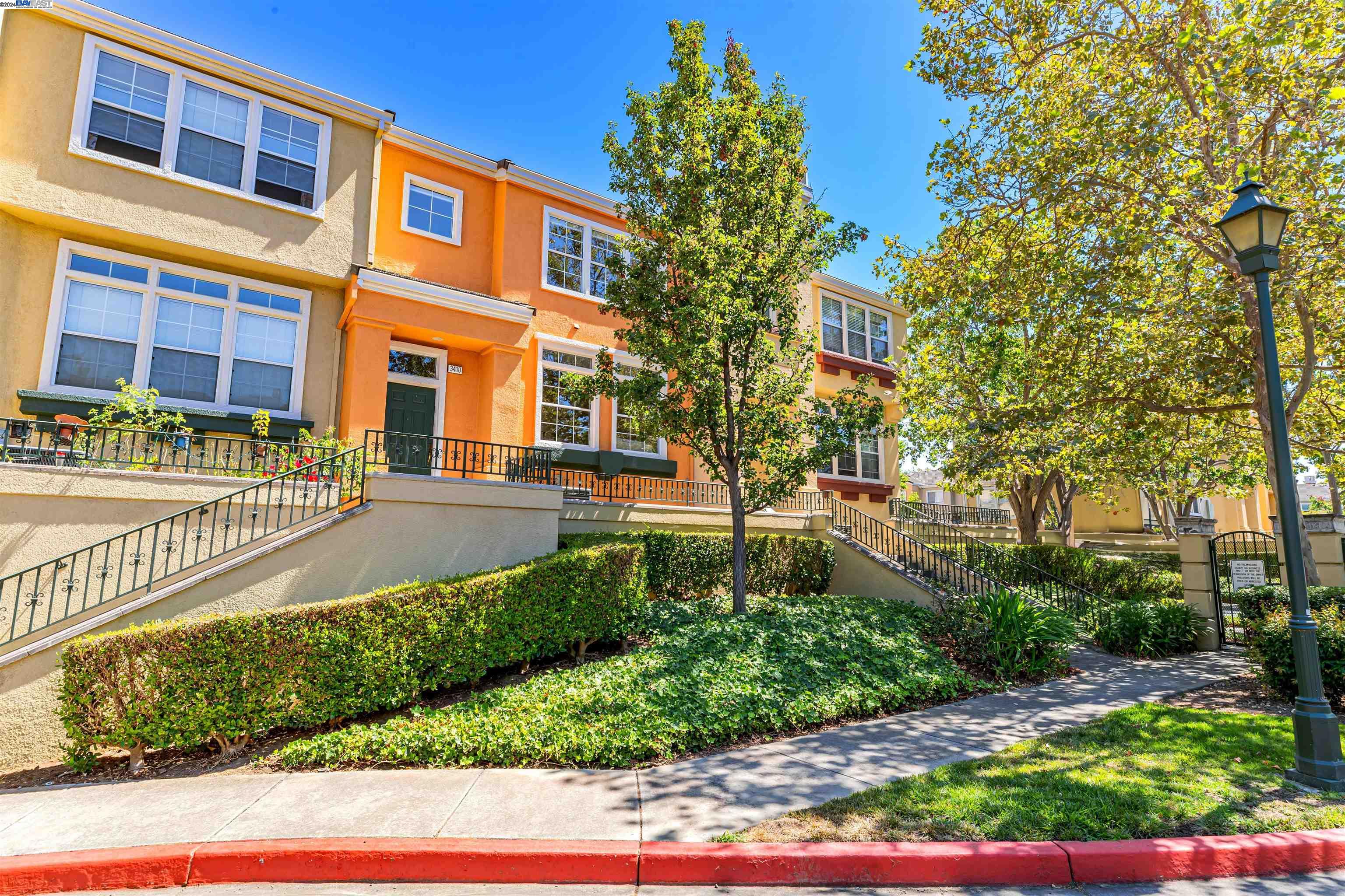 a front view of a multi story residential apartment building with yard and car parked