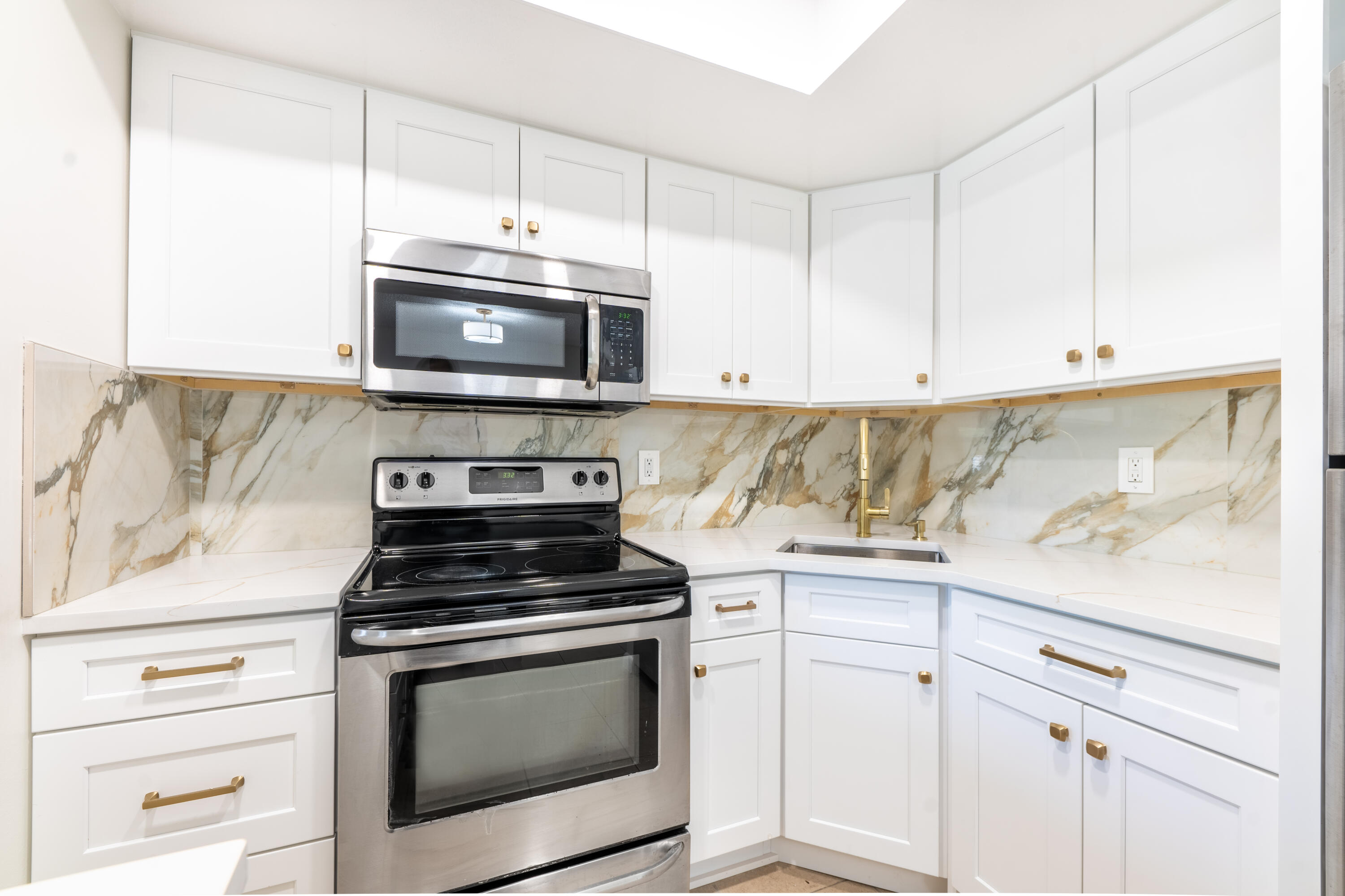 a kitchen with granite countertop white cabinets and stainless steel appliances